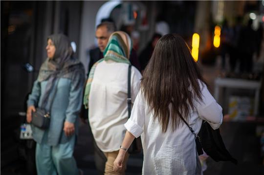 Eine Frau läuft im Juli 2023 mit offenen Haaren durch Teheran. Vor mehr als einem Jahr hatte der Tod der jungen Kurdin Jina Mahsa Amini die bislang schwersten Proteste in der Geschichte der Islamischen Republik ausgelöst. Viele Frauen zeigten sich daraufhin ohne Kopftuch in der Öffentlichkeit.