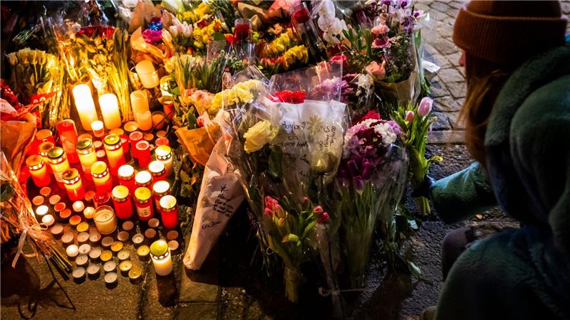 Eine Frau legt Blumen in der Nähe des Ortes nieder, an dem während der Neujahrsfeierlichkeiten in der Bar und Lounge „Le Constellation“ in Crans-Montana ein Brand ausgebrochen war, der Todesopfer und Verletzte forderte.