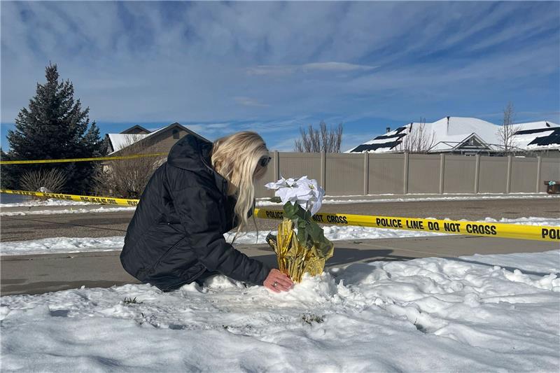 Vater in den USA soll eigene Familie erschossen haben Eine Frau legt Blumen vor dem Haus ab, in dem acht Familienmitglieder tot aufgefunden wurden.