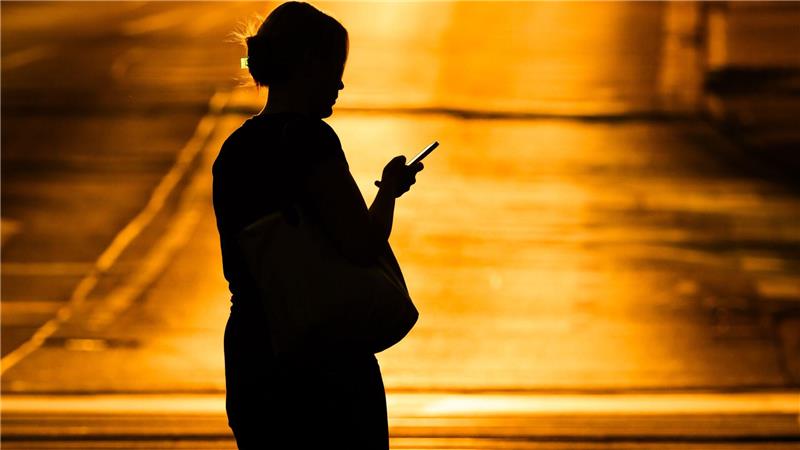 Eine Frau mit Handy - in der Netflix-Doku „Unbekannte Nummer: Der Highschool-Catfish“ kommt der Psychoterror via Smartphone. (Symbolbild)