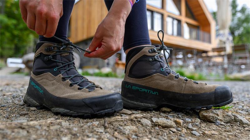 Wanderweg als Wirtschaftsmotor: Wie Gäste umworben werden Eine Frau schnürt ihre Wanderschuhe. Deutschland gilt mit seinen vielfältigen Landschaften und Regionen als Wanderland.