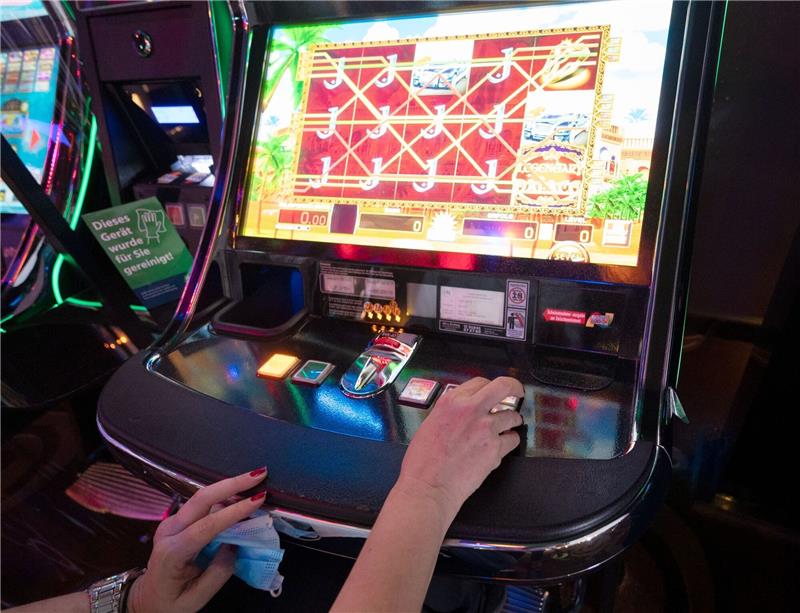 Viele Bremer Spielhallen bekommen keine Betriebserlaubnis Eine Frau sitzt in einer Spielhalle vor einem Automatenspiel.