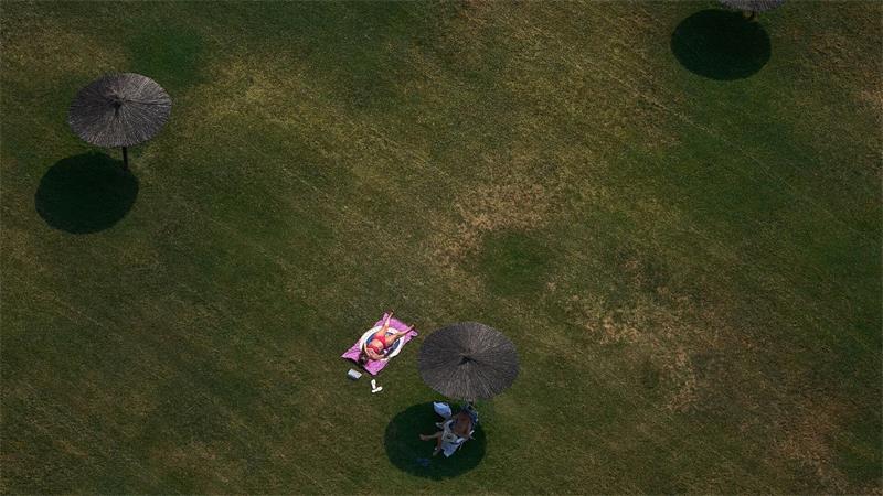 Eine Frau sonnt sich an einem Sommertag mit hohen Temperaturen in Pamplona.
