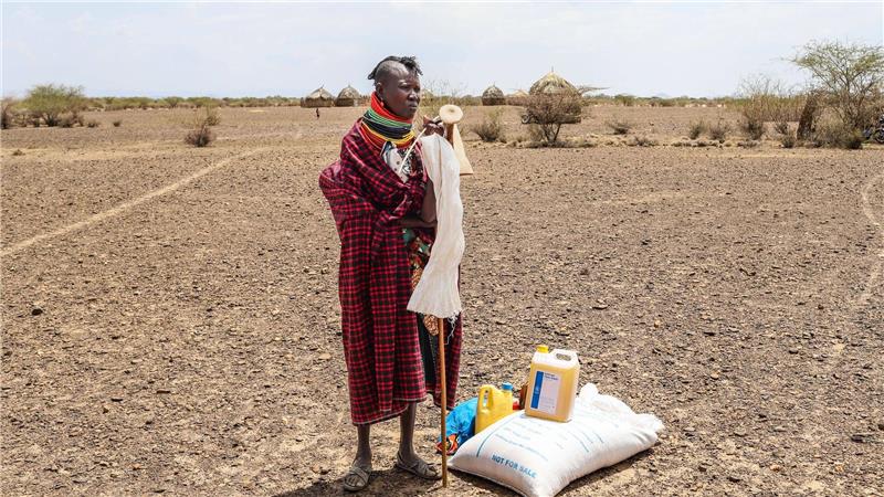 Eine Frau steht in Kenia neben einer Lebensmittelration des Welternährungsprogramms (WFP).