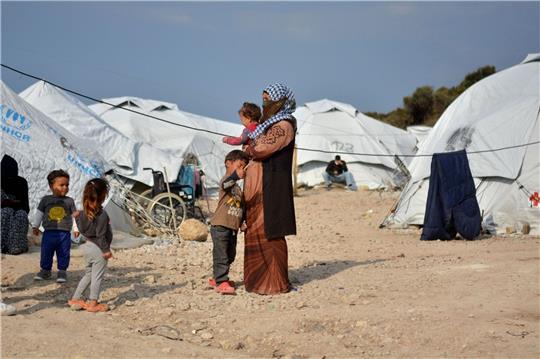 Eine Frau steht mit ihren Kindern im Flüchtlingslager Kara Tepe in der Nähe von Mytilini auf Lesbos.