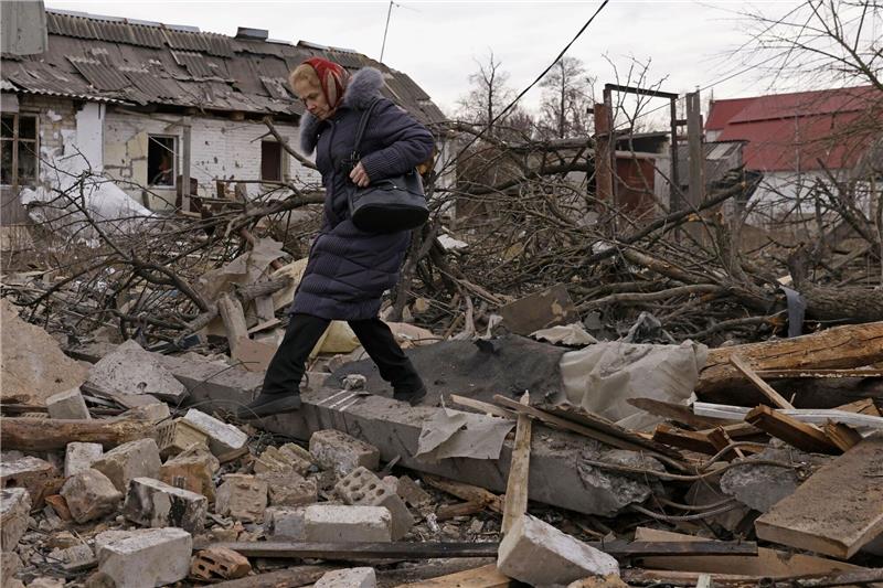 Krieg gegen die Ukraine: So ist die Lage Eine Frau steigt in Kiew über Trümmer von Gebäuden.