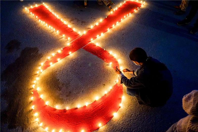 Welt-Aids-Konferenz: Millionen Infizierte ohne Therapie Eine Frau stellt Kerzen auf, die eine rote Schleife formen - ein weltweit anerkanntes Symbol für die Solidarität mit HIV-Infizierten.