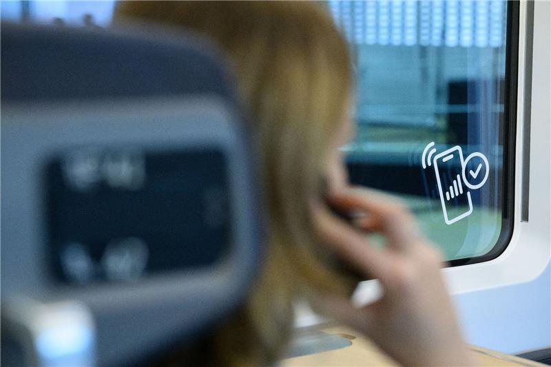 Der Mobilfunk an Bahnstrecken wird besser Eine Frau telefoniert in einem ICE: Das Handynetz an Deutschlands Bahnstrecken ist besser geworden.