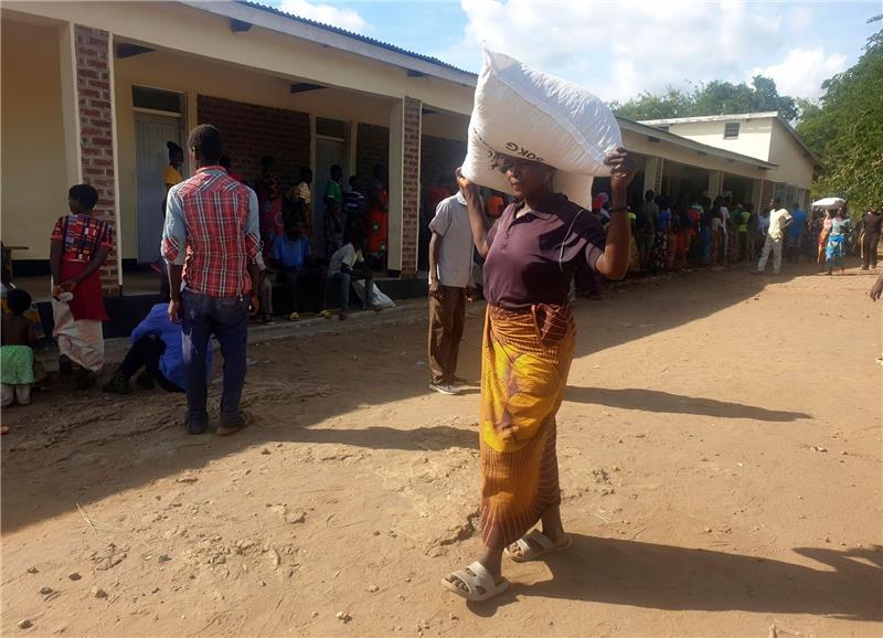 Dürre: Simbabwe erklärt Katastrophenzustand Eine Frau trägt einen Sack mit Maismehl, den sie in einem Verteilungszentrum des Welternährungsprogramms erhalten hat: Im südlichen Afrika wurde der Notstand ausgerufen.