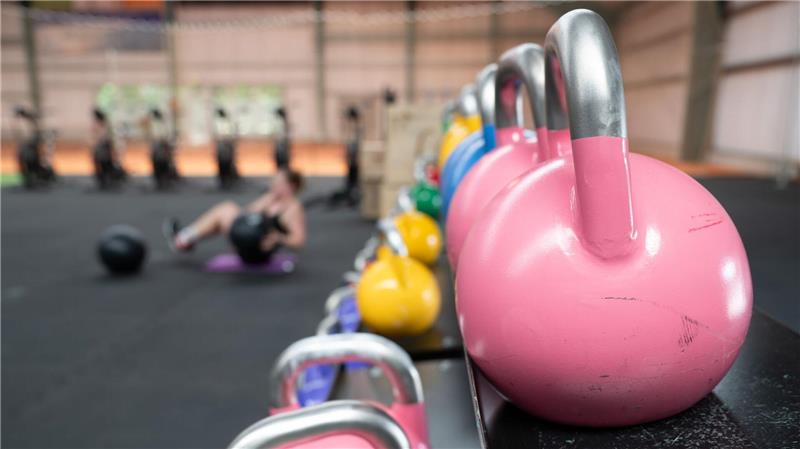 Eine Frau übt an einer Hantelbank.