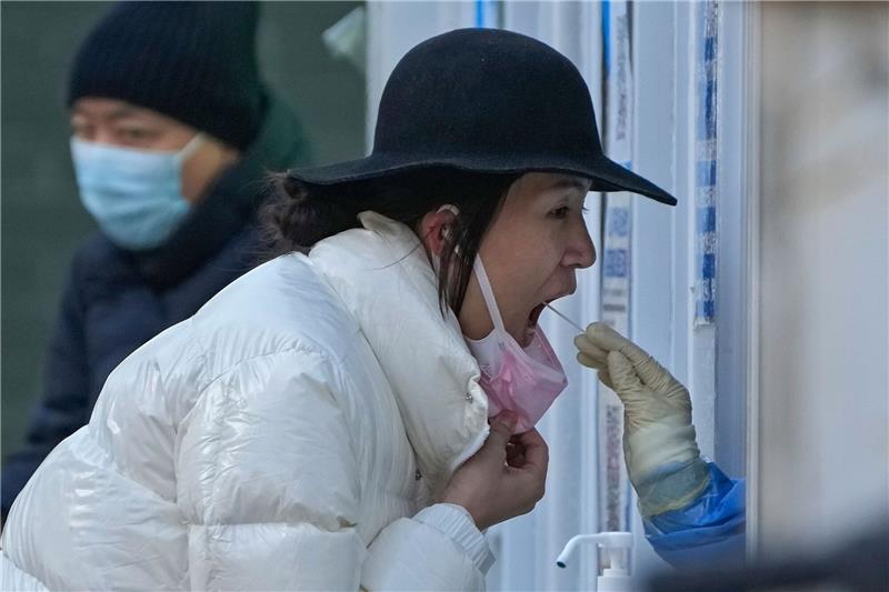 Heftige Corona-Infektionswelle in China befürchtet Eine Frau unterzieht sich in einer Coronavirus-Teststelle in Peking einem routinemäßigen COVID-19-Rachenabstrich.