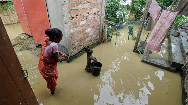 Über 30 Tote in Indien bei Überflutungen und Erdrutschen Eine Frau versucht in der überfluteten Umgebung ihres Hauses, Wasser zu sammeln.