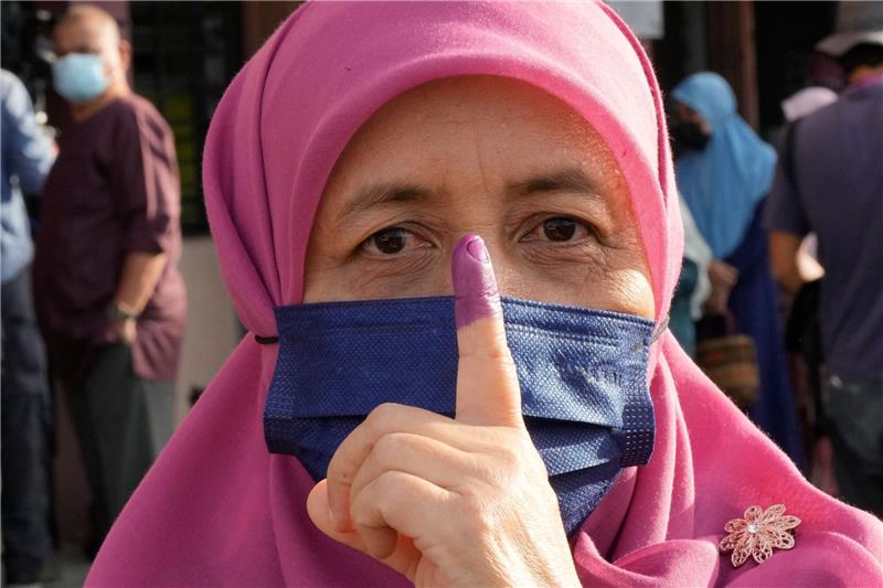 Enges Rennen bei Parlamentswahl in Malaysia Eine Frau zeigt ihren eingefärbten Finger nach der Stimmabgabe in Seberang Perai.