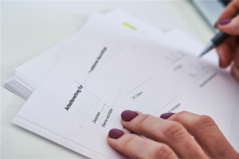 Studie: Frauen auf dem Arbeitsmarkt noch immer benachteiligt Eine Frauenhand unterschreibt einen Arbeitsvertrag.