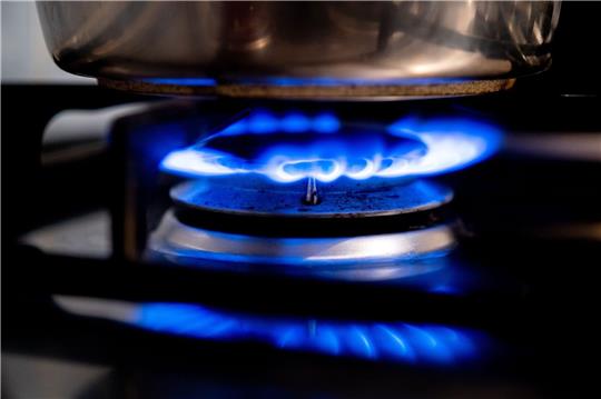 Eine Gasflamme brennt auf einem Küchenherd.