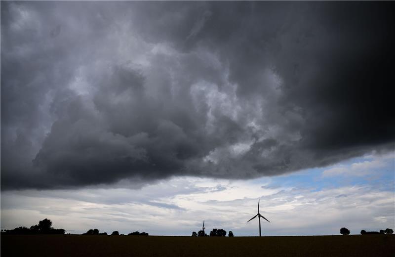 Gewitter und Schauer in Niedersachsen und Bremen Eine Gewitterfront zieht über ein Windrad in der südlichen Region Hannover hinweg.