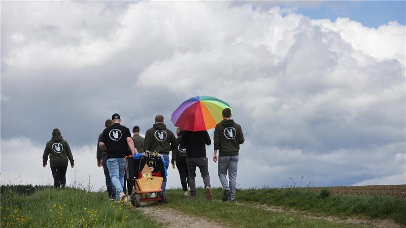 Eine Gruppe Männer und Frauen sind an Vatertag mit einem Bollerwagen unterwegs.