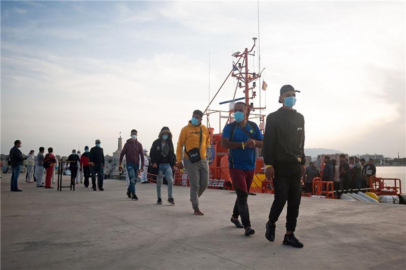 EU-Staaten einig: Asylverfahren sollen verschärft werden Eine Gruppe maghrebinischer Migranten wartet am Hafen in Malaga, nachdem sie von der spanischen Küstenwache im Mittelmeer gerettet wurde.