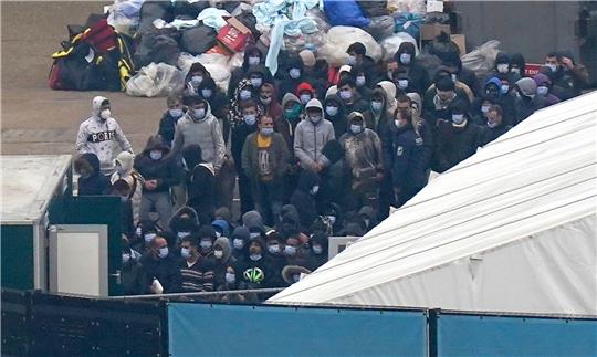 Eine Gruppe von Personen, bei denen es sich vermutlich um Migranten handelt, wartet auf ihre Registrierung in Dover.