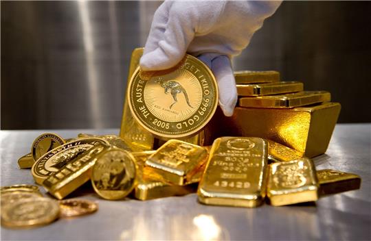 Eine Hand hält bei einem Goldhändler eine 1000g-Goldmünze - eine «Nugget Känguruh».