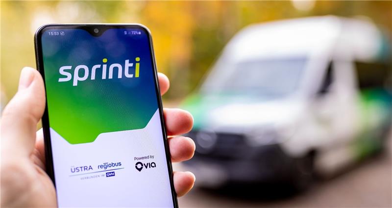 Eine Hand hält ein Smartphone auf dessen Bildschirm die Startmaske der App «Sprinti», einem Projekt der Üstra Hannoversche Verkehrsbetriebe und Regiobus, zu sehen ist.
