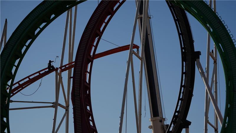 Eine Höhenkletterin nimmt bei den Aufbauarbeiten eine Schiene der Achterbahn auf dem Heiligengeistfeld in Hamburg entgegen. Der Aufbau für den Frühlingsdom hat begonnen. 