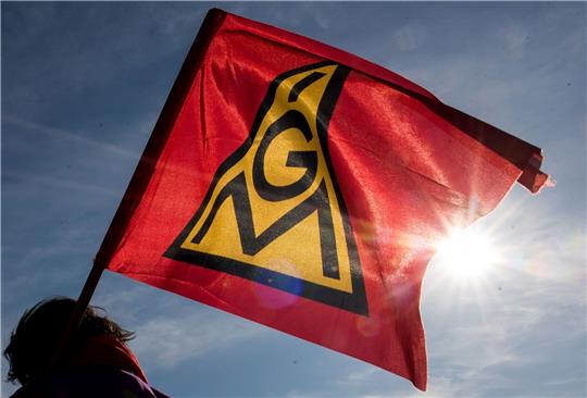 Eine IG-Metall-Fahne weht im Wind.