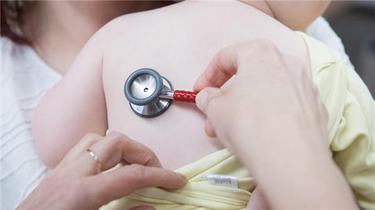 Eine Kinderärztin untersucht ein einjähriges Mädchen mit einem Stethoskop. Eltern beklagen, dass sie im Landkreis Goslar kaum Termine für ihre Kinder bekommen.