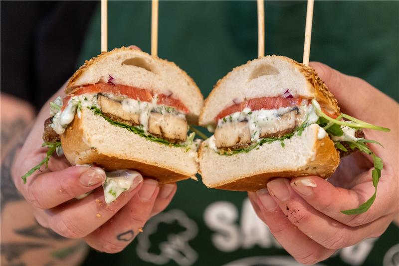 Garantiert grätenfrei – Vegane Fischalternativen erobern den Markt Eine Köchin zeigt einen veganen Fischersatz-Burger mit Tofu-Fischstäbchen im Algenblatt-Mantel. Foto: Daniel Karmann/dpa