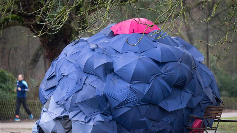 Eine Konstruktion aus Schirmen: Eine Frau hat sich bei einstelligen Temperaturen eine provisorische Bleibe in einem Park gebaut.