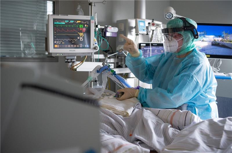 Corona-Welle lähmt Nahverkehr und Wirtschaft Eine Krankenschwester versorgt auf der Intensivstation einen Corona-Patienten. Foto: dpa-Bildfunk