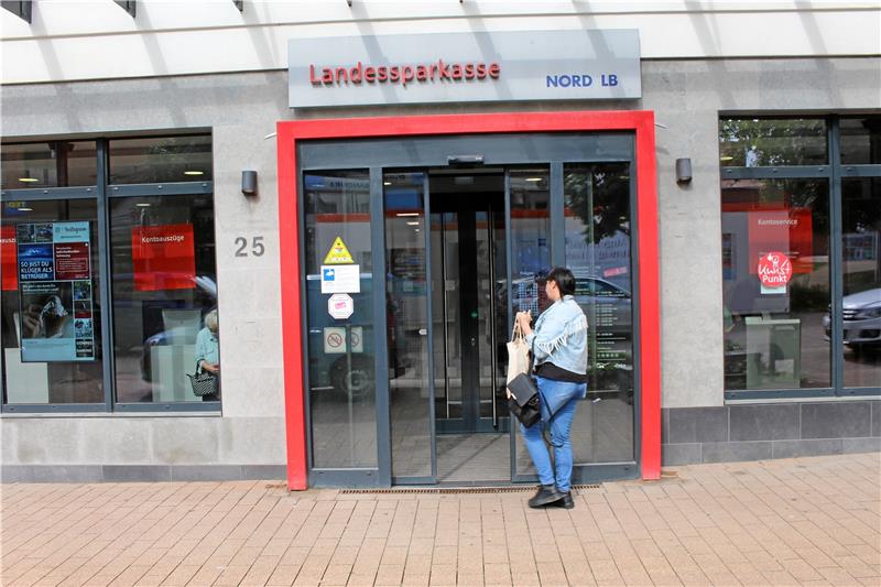 Eine Kundin betritt die Filiale der Seesener Landessparkassen über den Eingang an der Jaobsonstraße. Zur Mittagszeit bildet sich eine Schlange an den Geldautomaten. Foto: Wendt