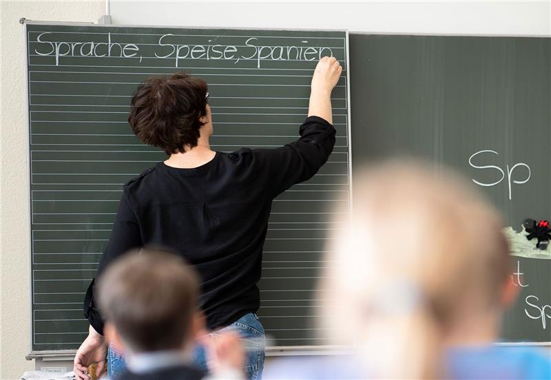 Lehrkräftemangel an Grundschulen bald überwunden Eine Lehrerin schreibt an die Tafel: An Grundschulen könnte es bald genug Lehrkräfte geben.