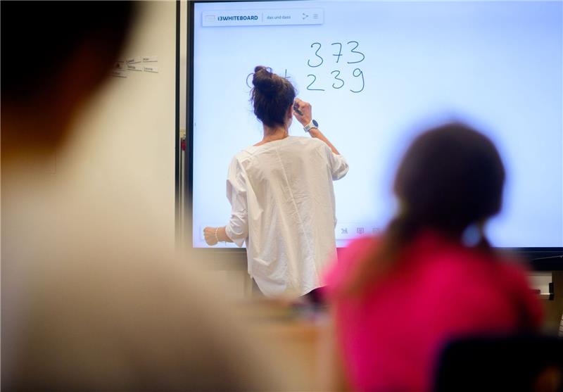Breites Bündnis fordert Fortsetzung des Digitalpakts Schule Eine Lehrerin schreibt eine Mathematikaufgabe auf eine digitale Schultafel im Klassenraum einer 4. Klasse einer Grundschule.