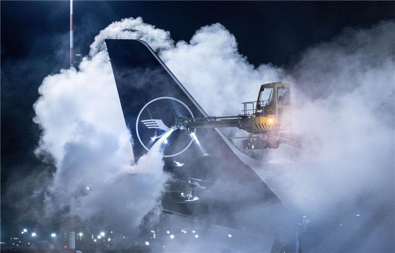Schnee und Eis bremsen Bahn- und Flugverkehr aus Eine Lufthansa-Maschine wird auf dem Flughafen Frankfurt enteist. Angesichts der Wetterlage hat der Flughafen den Flugplan zusammengestrichen.