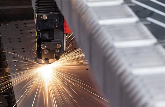 Eine Metallplatte wird in der Produktion eines mittelständischen Unternehmens in Sachsen bearbeitet.