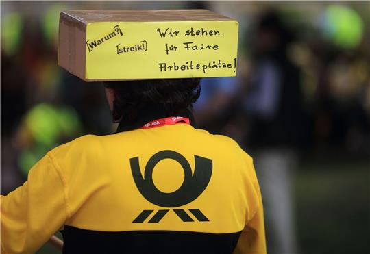 Eine Mitarbeiterin der Deutschen Post AG nimmt an einer Kundgebung der Gewerkschaft Verdi teil.