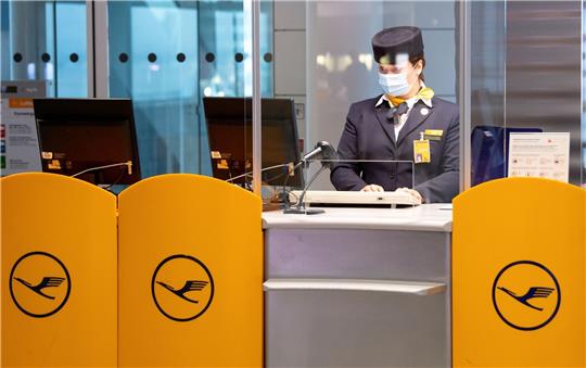 Eine Mitarbeiterin der Lufthansa bereitet an einem Gate am Flughafen München das Boarding für einen Flug vor. Verdi fordert mehr Geld für das Bodenpersonal. (Archivbild)