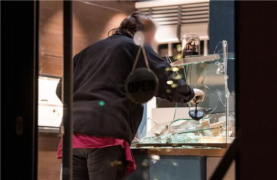 Eine Mitarbeiterin der Spurensicherung untersucht nach dem Überfall eine eingeschlagene Vitrine.