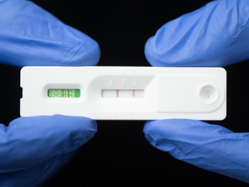 Eine Mitarbeiterin hält in einem Corona-Testcenter einen positiven Corona-Schnelltest. (Archivbild). Foto: Sebastian Kahnert/dpa-Zentralbild/dpa