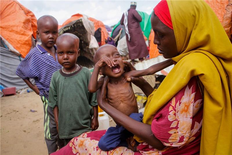UN: 43 Millionen Klima-vertriebene Minderjährige Eine Mutter, die aus der von Dürre heimgesuchten Region Lower Shabelle geflohen ist, hält ihre unterernährte Tochter in einem Lager für Vertriebene.