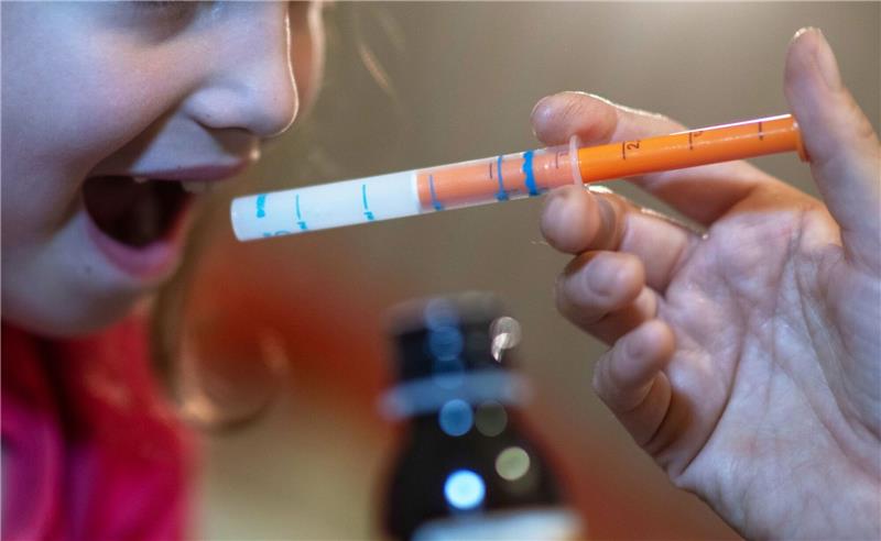 Ministerium: Versorgung mit wichtiger Kinderarznei gesichert Eine Mutter verabreicht ihrer Tochter eine Dosis Fiebersaft. (Symbolbild)