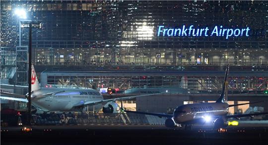 Eine Passagiermaschine der Ryanair (r) rollt nach Sonnenuntergang am Terminal 2 des Frankfurter Flughafens neben einem Flugzeug der Japan Airlines zur Startbahn. Der Flughafen sucht Personal.