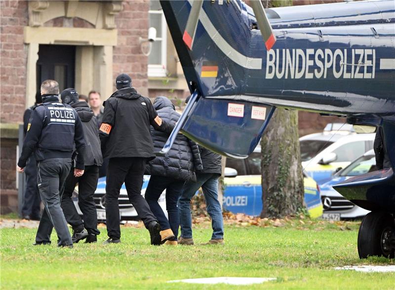 Razzia in „Reichsbürger”-Szene: Suche nach weiteren Spuren Eine Person (2.v.r.) wird von Polizisten aus einem Hubschrauber gebracht.