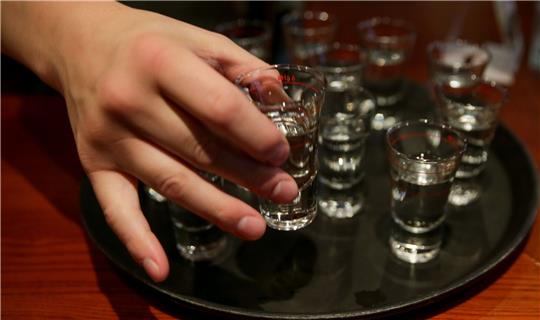 Eine Person greift nach einem gefüllten Schnapsglas. Mehr als zehn Millionen Menschen sterben laut der Weltgesundheitsorganisation (WHO) jedes Jahr durch Alkoholkonsum oder ungesunde Ernährung.