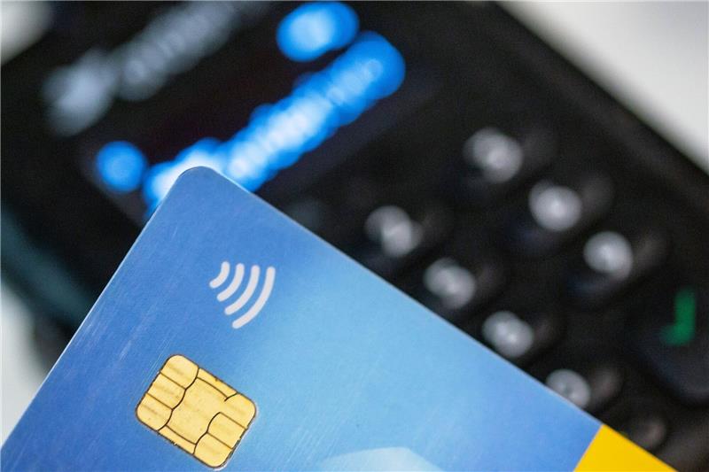 Bargeldloses Bezahlen per Girocard hat weiter zugenommen Eine Person hält ihre Girokarte über ein EC-Lesegerät zwecks kontaktlosem Bezahlen.
