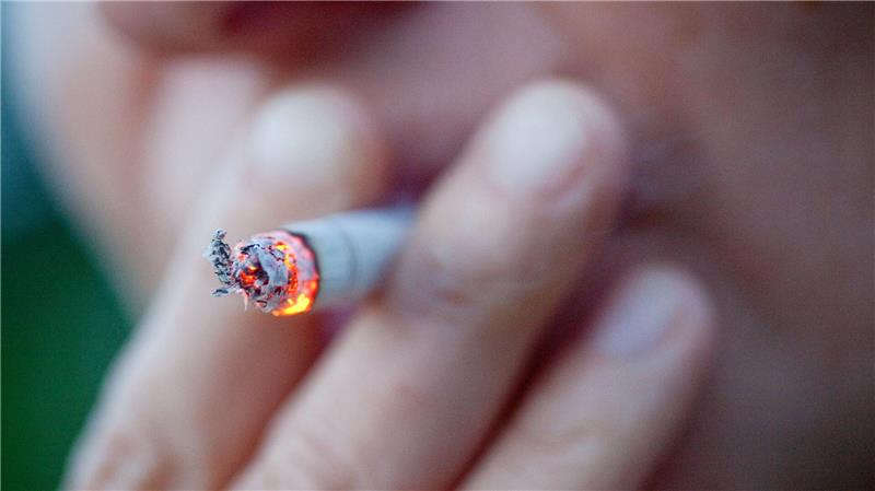 Eine Person zieht an einer Zigarette.