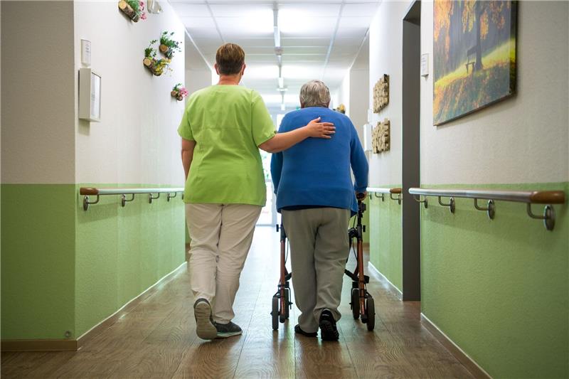 Verbände warnen vor Kollaps in der Pflege in Niedersachsen Eine Pflegefachkraft geht mit einer Bewohnerin durch ein Seniorenheim.