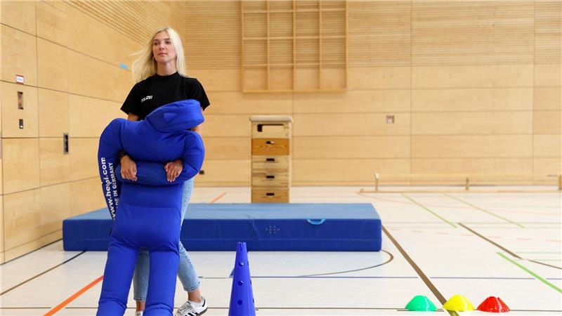 Eine Polizeikommissarin demonstriert die Personenrettung mit der 70 Kilogramm schweren Puppe.