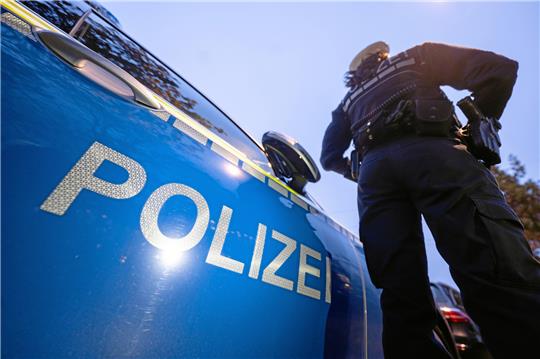 Eine Polizistin steht neben einem Polizeiauto. Foto: dpa